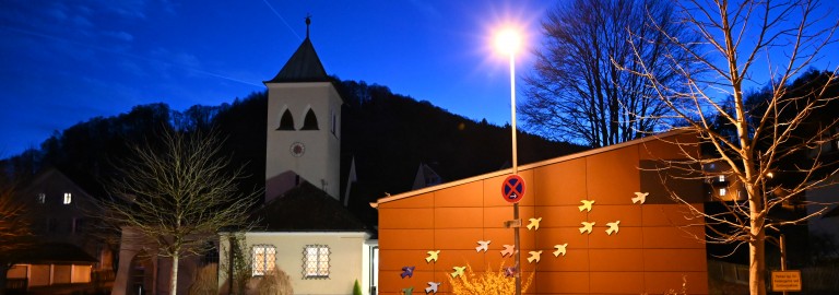 Gemeindehaus und Kirche Pbg am Abend